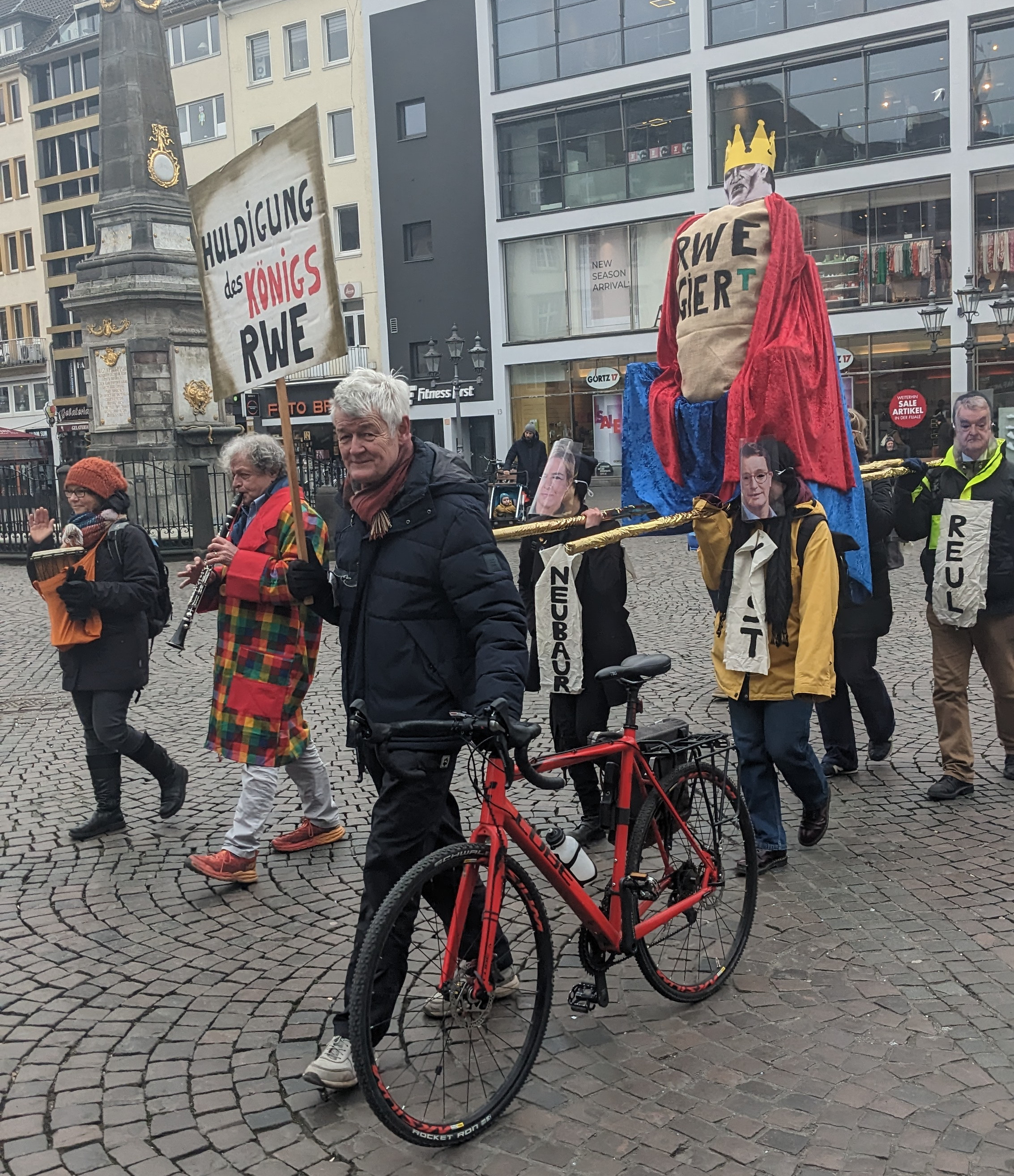 Der König RWE wird auf eine Sänfte von Neubaur, Wüst, Reul getragen