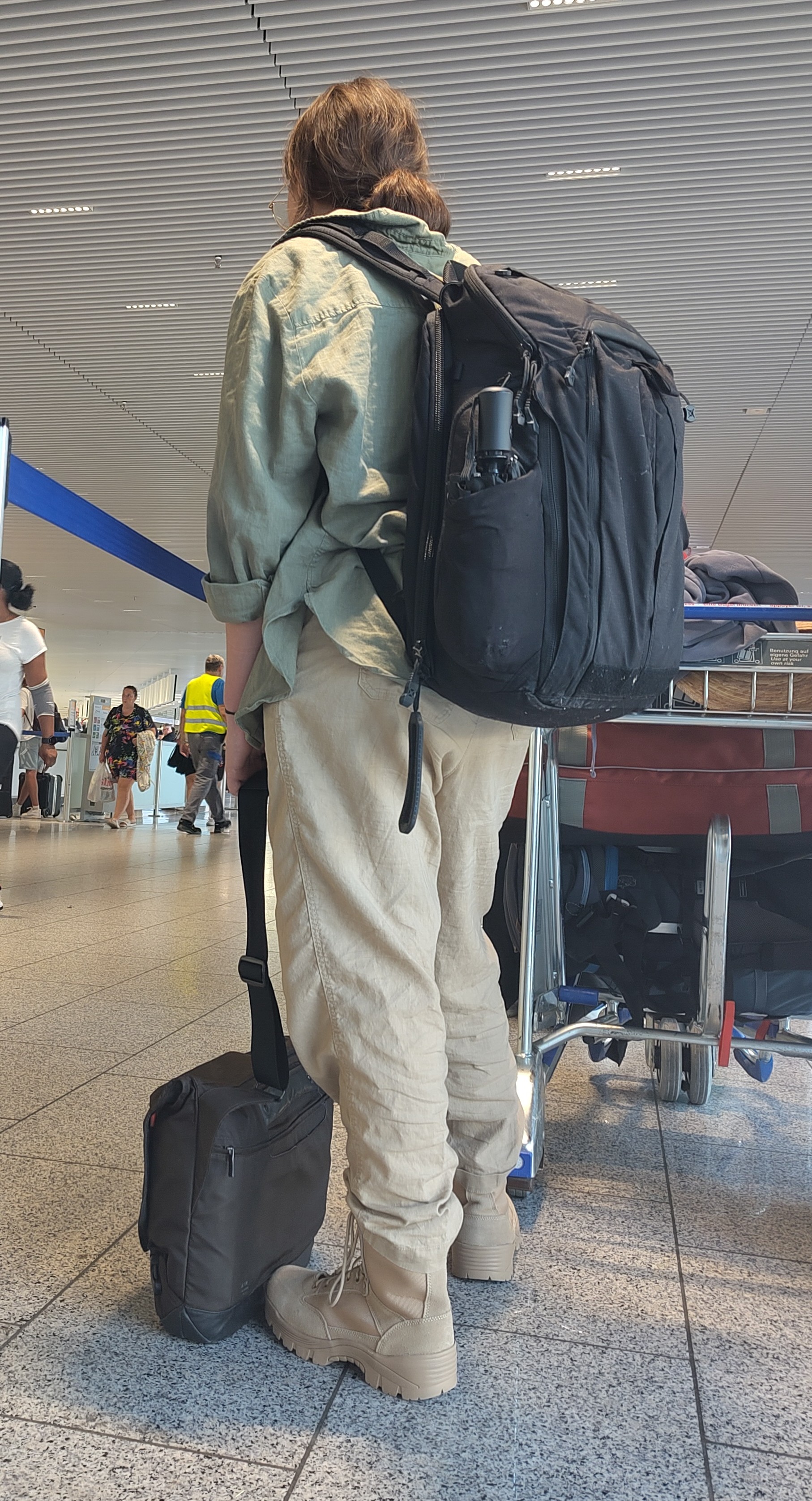 Eine junge Frau steht auf dem Flughafen bei der Gepäckaufgabe