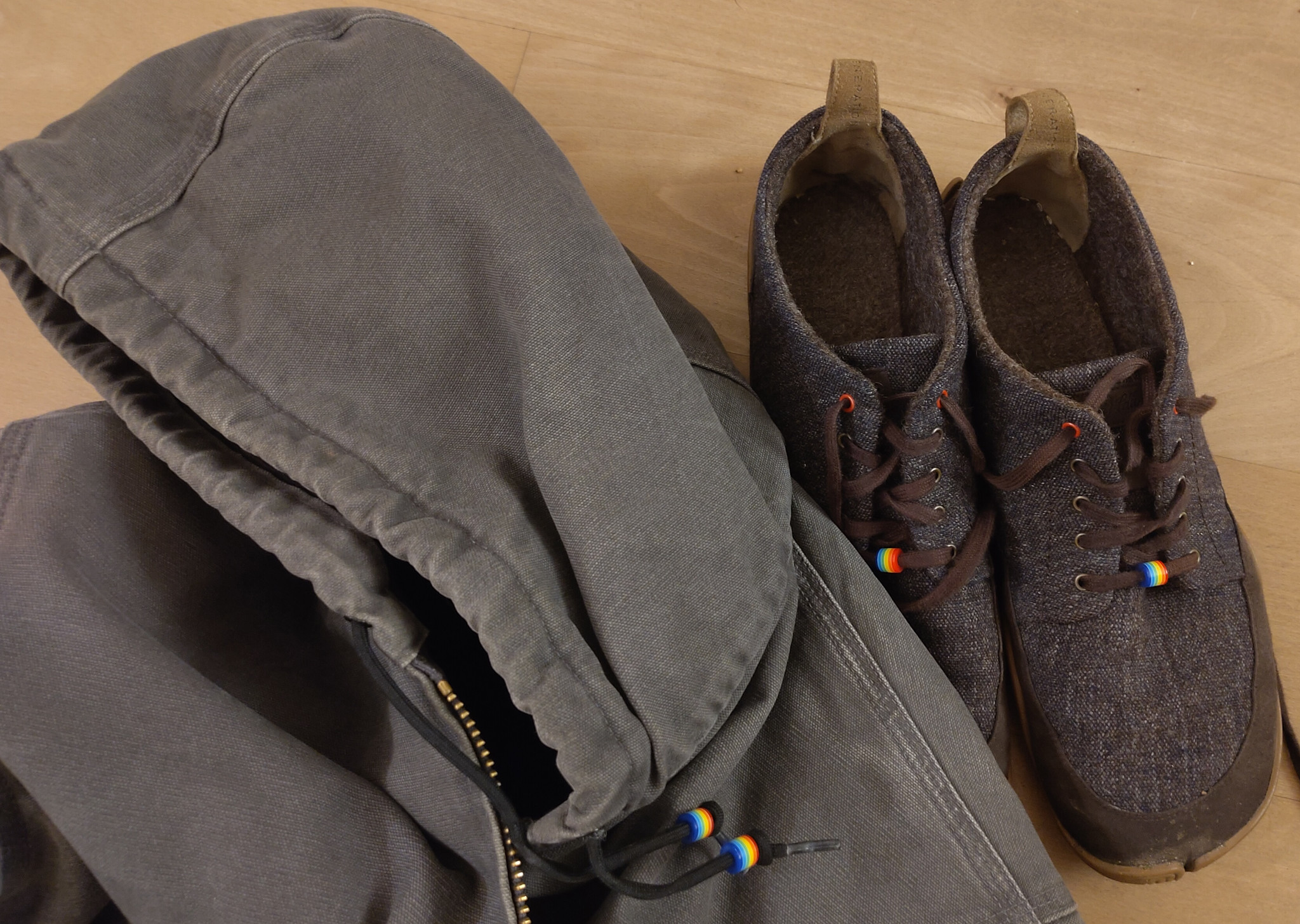 Plastikringe in Regenbogenfarbe an der Jacke und den Schnürsenkeln