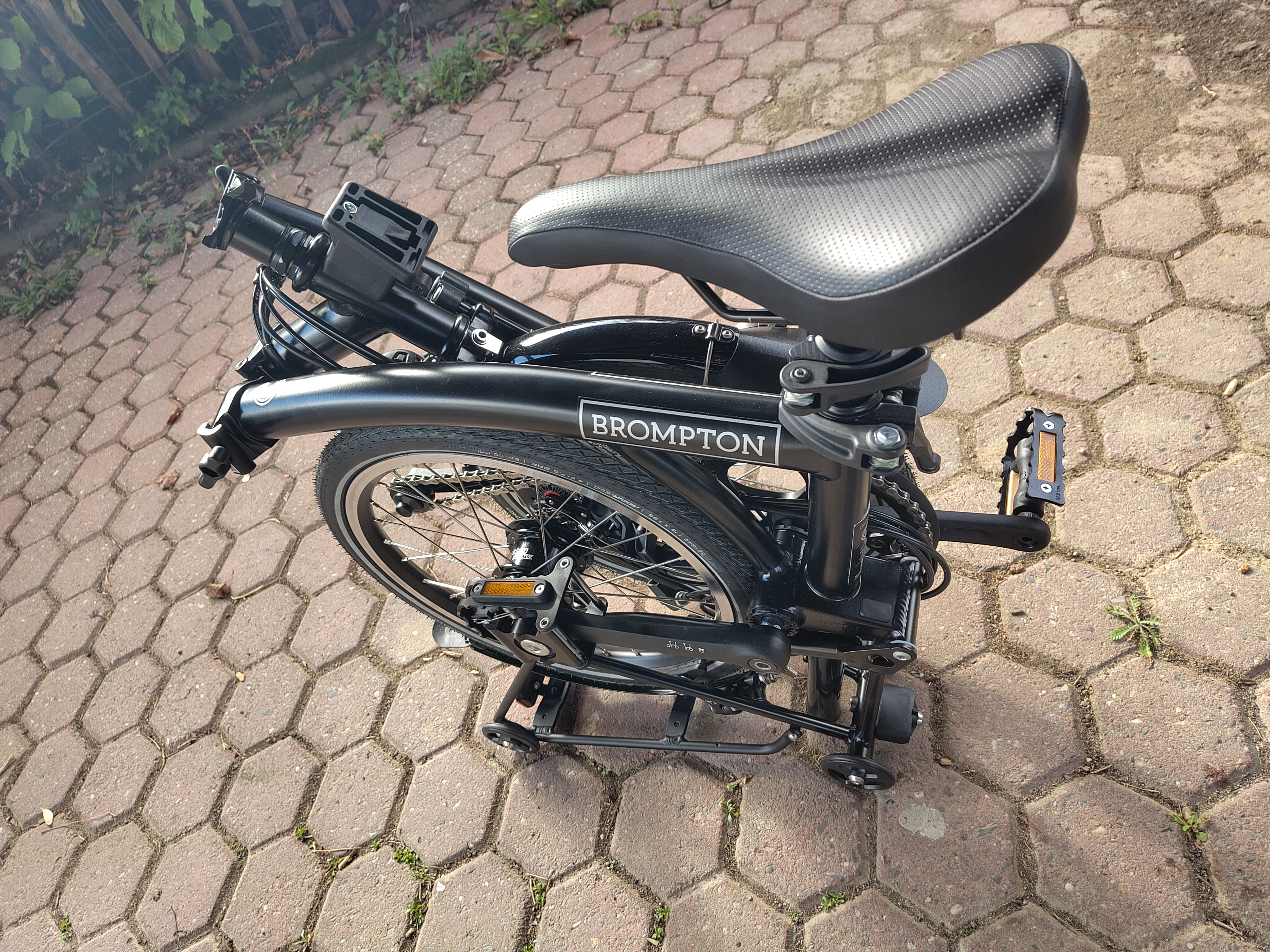 Ein zusammengeklapptes schwarzes Faltrad der Marke Brompton